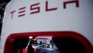 A Tesla electric vehicle (EV) is seen through a charging point displayed during a media day for the Auto Shanghai show in Shanghai, China April 20, 2021. REUTERS/Aly Song
