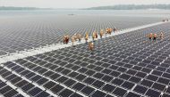 Workers walk between solar cell panels over the water surface of Sirindhorn Dam in Ubon Ratchathani, Thailand April 8, 2021. Picture taken April 8, 2021 with a drone. REUTERS/Prapan Chankaew