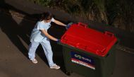 A worker disposes of waste outside a quarantine hotel where returning travelers are kept in isolation for a period to curb the spread of the coronavirus disease (COVID-19) in Sydney, Australia, August 21, 2020. REUTERS/Loren Elliott

