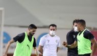 Al Sadd captain Hassan Al Haydos (left) practises with the ball as
Xavi Hernandez (second right) looks on during a training session. 