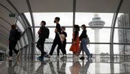 People pass the control tower of Singapore's Changi Airport, Singapore January 18, 2021. REUTERS/Edgar Su

