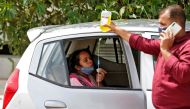 A relative holds a bottle of medicine administered to a patient sitting inside a car waiting to enter a COVID-19 hospital for treatment, amidst the spread of the coronavirus disease (COVID-19) in Ahmedabad, India, April 26, 2021. REUTERS/Amit Dave