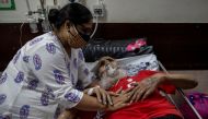 A man suffering from the coronavirus disease (COVID-19) is comforted by his daughter as he receives treatment inside the casualty ward at a hospital in New Delhi, India, May 1, 2021. REUTERS/Danish Siddiqui 