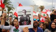File photo: Demonstrators carry Lebanese flags and a banner depicting Lebanon's Central Bank Governor Riad Salameh, as they head towards the central bank building during an anti-government protest in the southern city of Tyre, Lebanon October 23, 2019. Re
