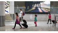 Travelers wearing protective face masks make their way through the arrivals section of the international terminal of Kingsford Smith International Airport the morning after Australia implemented an entry ban on non-citizens and non-residents intended to c