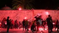 Palestinians react as Israeli police fire stun grenades during clashes at the compound that houses Al-Aqsa Mosque in Jerusalem on May 7, 2021. (REUTERS/Ammar Awad)