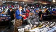 A vendor wears a protective mask at a fish and seafood stall at a local market during a nationwide 