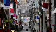 File photo: A man wearing a protective face mask, amid the coronavirus disease (COVID-19) pandemic, walks in a local shopping street decorated with Tokyo 2020 Olympic Games flags, in Tokyo, Japan, May 7, 2021. Reuters/Kim Kyung-Hoon/File Photo
