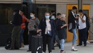 People, some wearing protective face masks, stand on a train platform at Central Station after new public health regulations were announced for greater Sydney, including compulsory mask-wearing on public transport, following the emergence of new cases of 