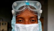 File photo: Beads of sweat run down the forehead of a healthcare worker wearing protective gear after she took swabs from the residents for rapid antigen test, amidst the coronavirus disease (COVID-19) outbreak, at a residential apartment in Ahmedabad, In