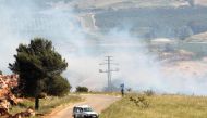 A UN peacekeeper (UNIFIL) stands as smoke rise in the southern Lebanese village of Khiam, near the border with Israel, Lebanon May 14, 2021. REUTERS/Aziz Taher