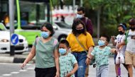 People wearing face masks cross a road amid the coronavirus disease (COVID-19) outbreak in Singapore May 14, 2021. REUTERS/Caroline Chia