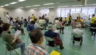 People wait to be processed after arriving to receive the Moderna coronavirus disease (COVID-19) vaccine at the newly-opened mass vaccination centre in Tokyo, Japan, May 24, 2021. Carl Court/Pool via Reuters