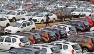 FILE PHOTO: A worker walks past parked Renault cars at its stockyard on the outskirts of the western Indian city of Ahmedabad June 11, 2013. Car sales in India fell an annual 12.3 percent in May, an industry body said on Tuesday, dropping for the seventh 