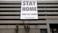 FILE PHOTO: A man walks beneath a billboard during the 21-day nationwide lockdown aimed at limiting the spread of coronavirus disease (COVID-19) in central Cape Town, South Africa, April 6, 2020. REUTERS/Mike Hutchings
