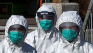 Health officers in full protective gear walk to a wholesale poultry market in Hong Kong December 31, 2014. REUTERS/Tyrone Siu/File Photo