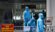 Medical workers in protective suits stand outside a quarantined building amid the coronavirus disease (COVID-19) outbreak in Hanoi, Vietnam, January 29, 2021. REUTERS/Thanh Hue/File Photo