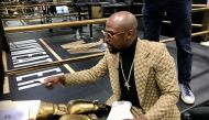 FILE PHOTO: Floyd Mayweather signs gloves at the opening of the Mayweather Boxing + Fitness gym in Torrance, California, U.S., November 16, 2019. REUTERS/Rory Carroll/File Photo
