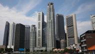 A woman wearing a protective face mask passes the city skyline during the coronavirus outbreak (COVID-19) outbreak in Singapore June 10, 2021. REUTERS/Edgar Su