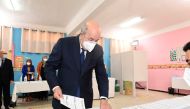 Algeria's President Abdelmadjid Tebboune prepares to cast his vote at a polling station during the country's parliamentary election in Bouchaoui, Algeria June 12, 2021. 