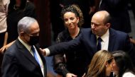 Head of Oposition Benjamin Netanyahu and Israel Prime Minister Naftali Bennett gesture following the vote on the new coalition at the Knesset, Israel's parliament, in Jerusalem June 13, 2021. REUTERS/Ronen Zvulun 