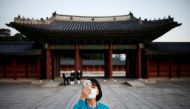 A woman takes photographs during a late-night admission which is offered for limited visitors amid the coronavirus (COVID-19) pandemic, at Changdeok Palace, in Seoul, South Korea, May 13, 2021. REUTERS/Kim Hong-Ji/File Photo