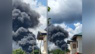 Residents gather as smoke rises from the wreckage, after a Philippines Air Force Lockheed C-130 transport plane, carrying troops, crashed on landing in Jolo, Sulu, Philippines July 4, 2021 in this image obtained from social media. Bogs Muhajiran via REUTE