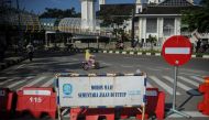 A girl rides a bicycle near barriers as Indonesia imposes emergency measures, tightening restrictions in Java and Bali amid a surge in coronavirus disease (COVID-19) cases, in Bandung, West Java Province, Indonesia July 4, 2021. Antara Foto/Raisan Al Fari