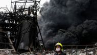 Emergency personnel looks on as smoke rises from a plastic factory after an explosion in Samut Prakan, outside Bangkok, Thailand July 5, 2021. REUTERS/Soe Zeya Tun
