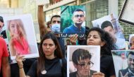 Family members of some of the victims of the August 4 explosion at Beirut port, carry their pictures during a protest demanding justice, in Beirut, Lebanon July 9, 2021. REUTERS/Mohamed Azakir