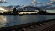 Harbour waterfront seating is devoid of people at sunset in front of the Sydney Harbour Bridge during a lockdown to curb the spread of a coronavirus disease (COVID-19) outbreak in Sydney, Australia, July 15, 2021. REUTERS/Loren Elliott/File Photo