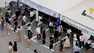 People wait in line for a coronavirus disease (COVID-19) test at a testing site which is temporarily set up at a public health center in Seoul, South Korea, July 9, 2021. REUTERS/ Heo Ran/File Photo