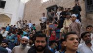People gather to see a camel slaughtering in celebration of Eid al-Adha, as the outbreak of the coronavirus disease (COVID-19) continues, in Peshawar, Pakistan July 21, 2021. REUTERS/Fayaz Aziz
