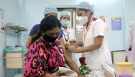 A healthcare worker holding a rose is vaccinated against COVID-19 at a medical centre in Mumbai, India, January 16, 2021. REUTERS/Francis Mascarenhas
