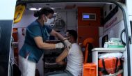 A man receives a dose of the Pfizer-BioNTech vaccine in an ambulance parked on a main street as medics use it to make a public announcement to convince people to get vaccinated amid a surge in COVID-19 cases in Diyarbakir, Turkey July 27, 2021. Picture ta