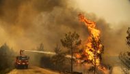 A firefighter extinguishes a forest fire near the town of Manavgat, east of the resort city of Antalya, Turkey, July 30, 2021. REUTERS/Kaan Soyturk