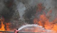 A firefighter tries to extinguish a wildfire near Marmaris, Turkey, August 1, 2021. REUTERS/Umit Bektas