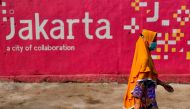 A woman wearing a protective mask walks near a traditional market amid the coronavirus disease (COVID-19) pandemic in Jakarta, Indonesia, July 30, 2021. REUTERS/Willy Kurniawan/File Photo