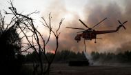 A helicopter is being filled up with water from a tank as a wildfire burns near the village of Kryoneri, north of Athens, Greece August 5, 2021. REUTERS/Costas Baltas
