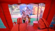 A medical worker collects a swab from a child for nucleic acid testing following the coronavirus disease (COVID-19) outbreak in Yangzhou, Jiangsu province, China August 9, 2021. China Daily via REUTERS