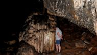 A guide looks at red ocher markings which were painted on stalagmites by Neanderthals about 65,000 years ago, according to an international study, in a prehistoric cave in Ardales, southern Spain, August 7, 2021. Picture taken August 7, 2021. REUTERS/Jon 