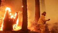 A firefighter continues to hold the line of the Dixie Fire near Taylorsville, California, U.S., August 10, 2021. REUTERS/David Swanson