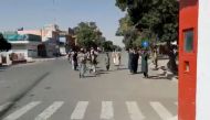 People gather on the street as Taliban fighters stand guard on main road intersection in city of Ghazni, Afghanistan in this screen grab taken from a video released by the Taliban on August 12, 2021. Taliban Handout/via Reuters 