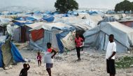 FILE PHOTO: Haitians made homeless in the 2010 earthquake stand outside their tents on the outskirts of Port-au-Prince January 13, 2011. REUTERS/Jorge Silva