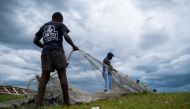 Two fishermen secure a fishing net on land, as Tropical Depression Grace approaches, after Saturday's 7.2 magnitude quake, in Les Cayes, Haiti August 16, 2021. REUTERS/Ricardo Arduengo