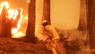 A firefighter continues to hold the line of the Dixie Fire near Taylorsville, California, U.S., August 10, 2021. REUTERS/David Swanson/File Photo