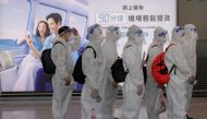 Passengers wearing protective suits (PPE) line up to board their plane for an international flight at Hong Kong airport amid the spread of the coronavirus disease (Covid-19), China July 9, 2021. Reuters/Thomas Peter//File Photo