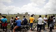 Residents look on as workers receive humanitarian aid from a U.S. military helicopter at Les Cayes airport after Saturday's 7.2 magnitude earthquake, in Les Cayes, Haiti, August 18, 2021. REUTERS/Henry Romero
