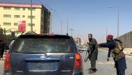 FILE PHOTO: Members of Taliban forces gesture as they check a vehicle on a street in Kabul, Afghanistan, August 16, 2021. REUTERS