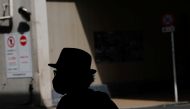 A man wearing a protective mask, amid the coronavirus disease (COVID-19) pandemic, is silhouetted in Tokyo, Japan, August 25, 2021. REUTERS/Kim Kyung-Hoon